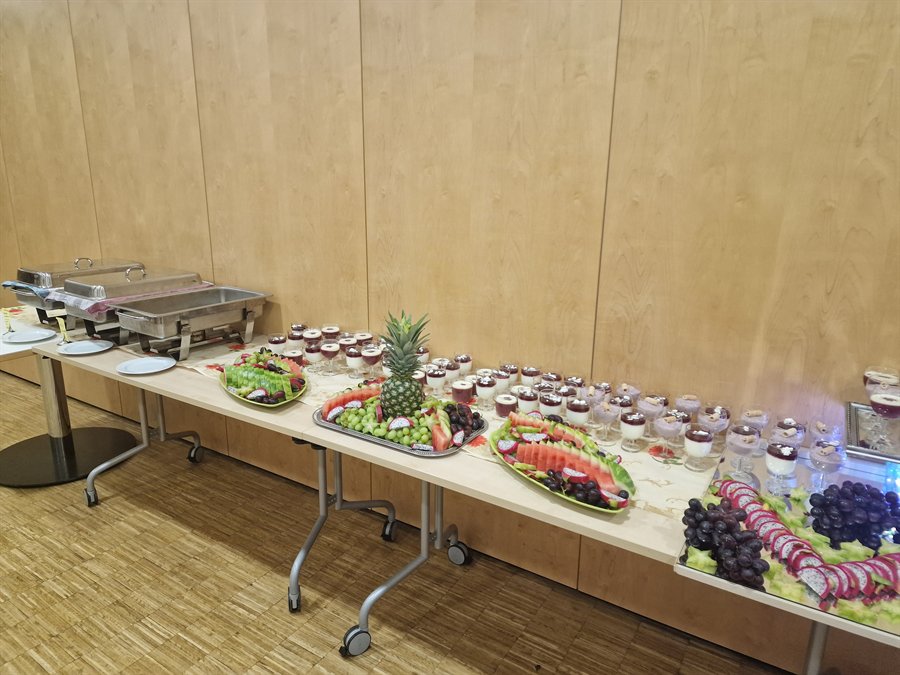 Lange Buffettafel mit Obstplatten, Desserts und warmen Speisen